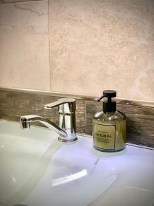 a bottle of soap sitting on top of a bathroom sink at Nordic Style Apartment with Underground parking in Sofia