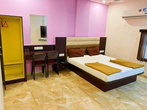 um quarto com uma cama, uma mesa e cadeiras em Hotel Narmada em Lāchharas