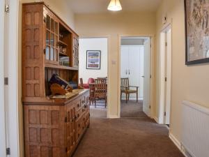 un corridoio con un grande mobile in legno e una sala da pranzo di 8 Lowther Gardens a Grange Over Sands