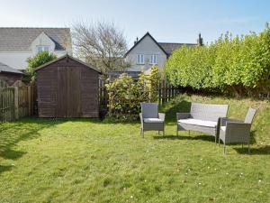 two chairs and a bench in a yard at Goslings in Marloes