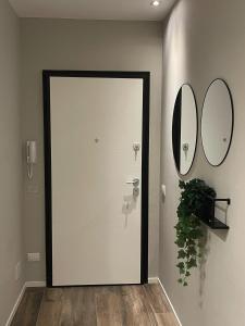 a door in a hallway with two mirrors on the wall at Casa Valla nuova e deliziosa dimora a Formigine in Formigine
