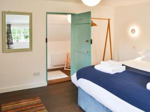 a bedroom with a bed and a mirror at Willow Cottage in Ludham