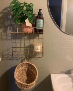 ein Badezimmer mit einem Korb, einem Spiegel und einem Waschbecken in der Unterkunft GÆSTEHUSET in Tarm