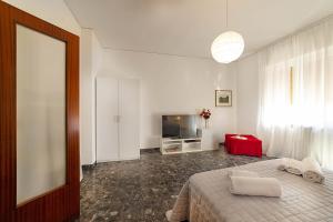 Residenza Dalia&Lea في فيرونا: غرفة نوم بسرير وتلفزيون ونافذة