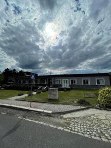 una casa al lado de una calle con un cielo nublado en RIKY Centrum, en Přestanov