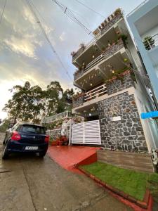 een auto geparkeerd voor een huis bij Emmanuel Inn in Kodaikānāl