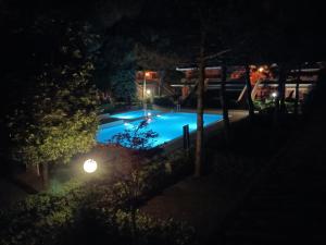 a swimming pool at night with a street light at Sa di Mare in Bibione