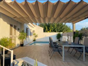 a patio with a table and chairs under a wooden umbrella at Casa Riumar Ebre in Riumar