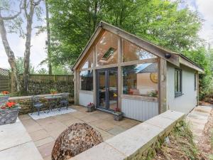 a small shed with glass doors and a patio at Ramblers Retreat in Tansley