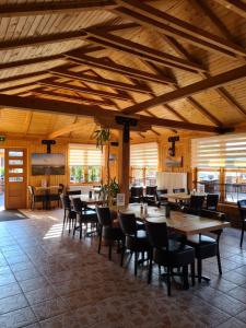 comedor con techos de madera, mesas y sillas en Hotel Elb Blick en Jork