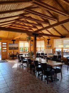 a dining room with wooden ceilings and tables and chairs at Hotel Elb Blick in Jork