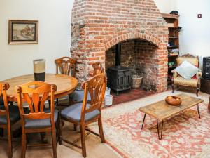- un salon avec une table et une cheminée en briques dans l'établissement Peggs Yard, à Aylsham