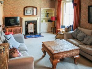 - un salon avec un canapé et une table dans l'établissement Peggs Yard, à Aylsham