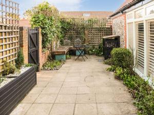 a garden with a bench and a fence at Peggs Yard in Aylsham