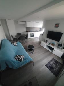 ein Schlafzimmer mit einem blauen Bett und ein Wohnzimmer in der Unterkunft gîte m et m in Nébouzat