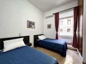 a bedroom with two beds and a window at Hotel domus termini in Rome