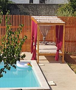 uma piscina no quintal com um baloiço e uma cama em Alice House 2 em Amarinthos