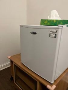 a white refrigerator sitting on top of a table at Juana's private room in Manchester