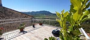 a balcony with potted plants and a view of mountains at Casa in the Clouds in Stimigliano