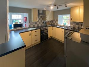 a kitchen with yellow cabinets and black counter tops at Arden House in Comrie
