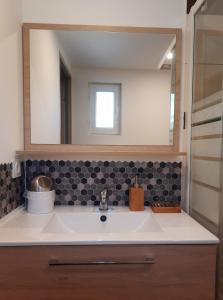 a bathroom with a sink and a mirror at Adorable petite maison au coeur du Luberon in Villelaure