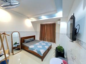 a small bedroom with a bed and a tv at Homestay The Fiii Come&Stay in Vung Tau