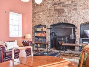 a living room with a large stone fireplace at Hayfield - Uk35890 in Turriff