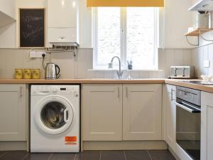 a kitchen with a washing machine and a sink at Dandelions in Newton Abbot
