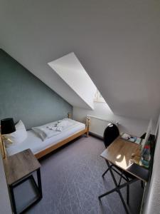 a small room with a bed and a table at Hotel Hennesburg in Eisenach +28 photos