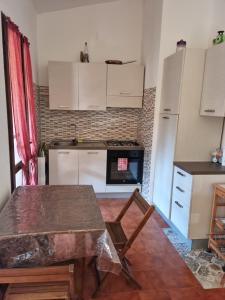 a kitchen with white cabinets and a table in it at Splendida Villetta vicino al mare in Villasimius