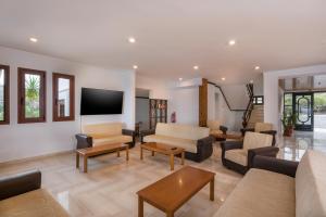 sala de estar con muebles y TV de pantalla plana en Lena Beach Hotel, en Kalathas