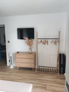a living room with a tv and a wooden dresser at Ravissante Suite 90m2 près des bord de Loire in Saint-Julien-de-Concelles