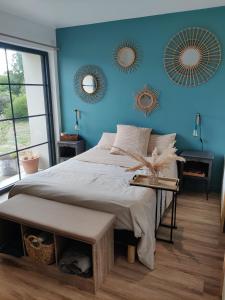 um quarto com uma cama e uma parede azul em Ravissante Suite 90m2 près des bord de Loire em Saint-Julien-de-Concelles