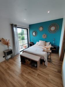 a bedroom with a bed and a blue wall at Ravissante Suite 90m2 près des bord de Loire in Saint-Julien-de-Concelles