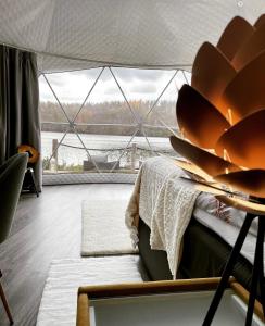 een kamer met een bed en een groot raam bij Maja Luxury Glamping Suites in Mäntyharju