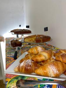 una mesa con varias bandejas de pan y bollería en Hotel Elios Tao, en Taormina