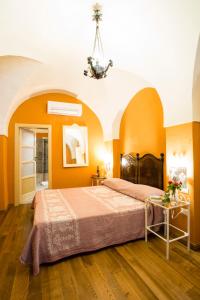 ein Schlafzimmer mit orangefarbenen Wänden und einem großen Bett in der Unterkunft Hotel Villa Gli Asfodeli in Tresnuraghes