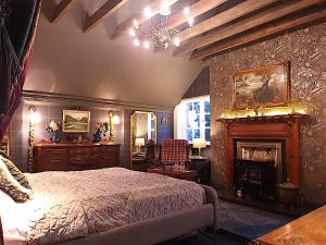 1 dormitorio con 1 cama y chimenea en Glencruitten House, en Oban