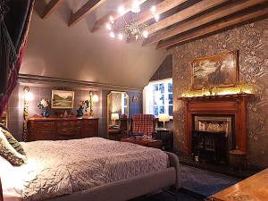 a bedroom with a bed and a fireplace at Glencruitten House in Oban