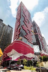 a tall red building in a city with cars at Arte + @ Jalan Ampang, KLCC Kuala Lumpur in Kuala Lumpur