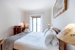 a bedroom with a large white bed with a window at IM On Ameijeira in Lagos