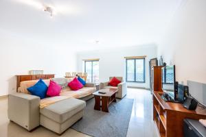 a living room with a couch and a television at IM On Ameijeira in Lagos