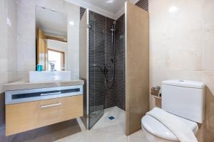 a bathroom with a toilet and a sink and a shower at IM On Ameijeira in Lagos +15 photos