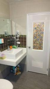 花蓮市的住宿－紫藤花民宿，一间带水槽的浴室和一个带镜子的门