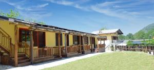 ein gelbes Haus mit Holzterrassen und einem Hof in der Unterkunft Le casette nel verde in Lurisia