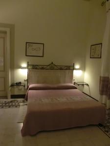 een bed in een slaapkamer met 2 lampen aan de muur bij Hotel Villa Gli Asfodeli in Tresnuraghes