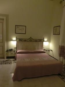 a bed in a bedroom with two lamps on the wall at Hotel Villa Gli Asfodeli in Tresnuraghes