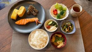 桥本Hostel Inn Hashimoto的餐桌,上面有一盘饭和蔬菜