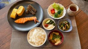 Hostel Inn Hashimoto في Hashimoto: طاولة مع طبق من الطعام مع الأرز والخضار
