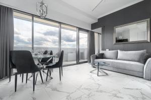 una sala de estar con una mesa y un sofá en Apartament w Hanza Tower, en Szczecin